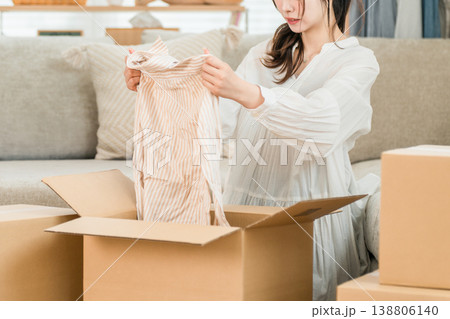家で引越しの荷造り,処分,断捨離をする若い女性 家で引越しの荷造り,処分,断捨離をする若い女性 138806140