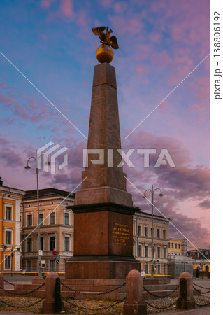 The Stone of the Empress (Keisarinnankivi) obelisk monument standing prominently in Market Square with historic buildings and the Uspenski Cathedral under a stunning sunset sky The Stone of the Empress (Keisarinnankivi) obelisk monument standing prominently in Market Square with historic buildings and the Uspenski Cathedral under a stunning sunset sky 138806192