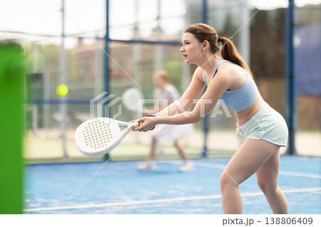 woman participates in a paddle tennis tournament woman participates in a paddle tennis tournament 138806409