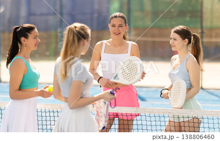 Female padel tennis players chatting on tennis court 138806460