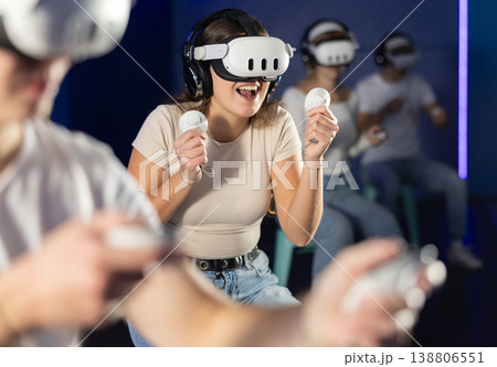 Girl in vr glasses with joysticks playing a video game 138806551