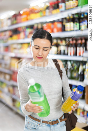 Woman in supermarket choose drink Woman in supermarket choose drink 138806614