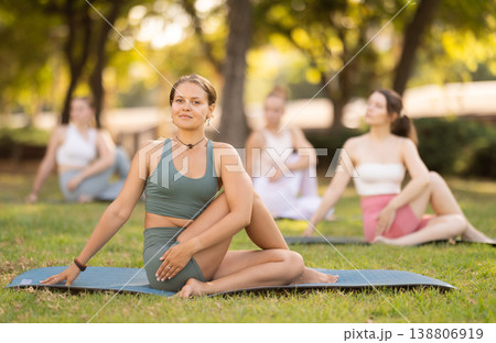 Group of young women doing yoga in park 138806919
