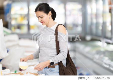 Adult woman pours rice into bag in store Adult woman pours rice into bag in store 138806970