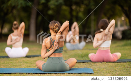 Yoga lesson visitors girls perform Paschima Namaskarasana in park Yoga lesson visitors girls perform Paschima Namaskarasana in park 138806991