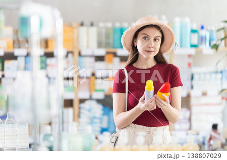 Young woman chooses repellent at pharmacy 138807029