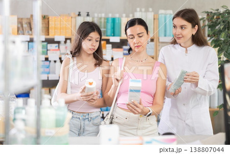 Woman with daughter choosing cream with pharmacist 138807044