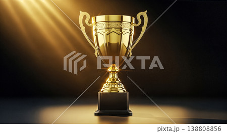Shiny golden trophy cup illuminated by bright spotlight against dark background symbolizing ultimate business success sporting victory professional championship achievement or top award 138808856