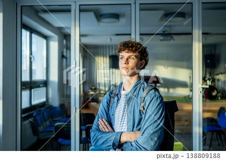 Confident teen student standing in modern classroom. 138809188