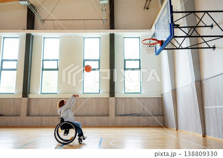 Wheelchair basketball player shooting ball towards hoop. Wheelchair basketball player shooting ball towards hoop. 138809330