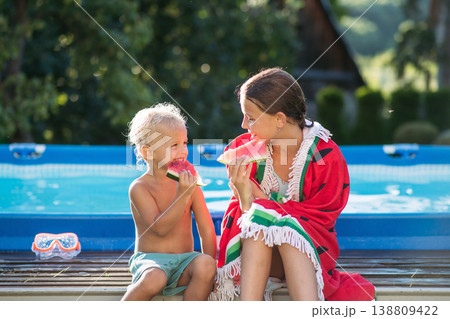 Sister and toddler brother eating watermelon after swimming in pool. Sister and toddler brother eating watermelon after swimming in pool. 138809422