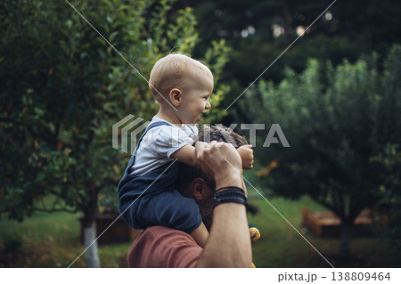 Father holding baby daughter while spending time together in garden. 138809464
