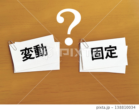 ゼムクリップで留めたメモの束2つ_変動と固定とクエスチョンマーク文字入り ゼムクリップで留めたメモの束2つ_変動と固定とクエスチョンマーク文字入り 138810034