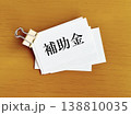 ダブルクリップで挟んだ何枚かの補助金文字入りメモ用紙 138810035