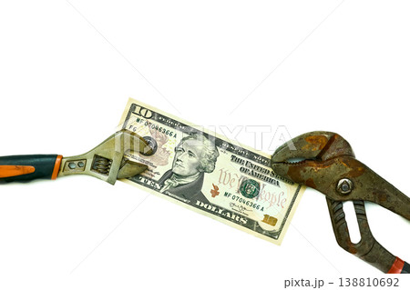 Ten dollars bill between old adjustable wrenches Ten dollars bill between old adjustable wrenches 138810692