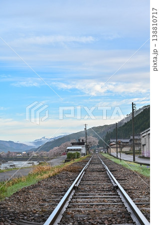 雪山と桜を背景にした晴天の日の長良川鉄道の線路の風景写真 【岐阜 郡上風景】 雪山と桜を背景にした晴天の日の長良川鉄道の線路の風景写真 【岐阜 郡上風景】 138810717