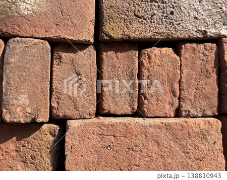 Closeup of rustic red brick wall with rough texture, ideal for architectural or construction background Closeup of rustic red brick wall with rough texture, ideal for architectural or construction background 138810943