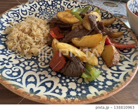 Beef stir-fry with rice on a decorative plate featuring vegetables and sliced tender beef 138810963