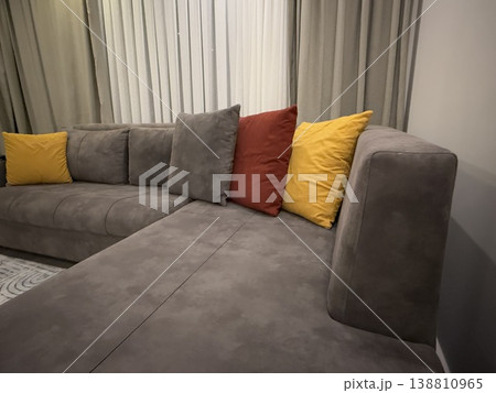 Modern gray sectional sofa with colorful pillows in cozy living room background Modern gray sectional sofa with colorful pillows in cozy living room background 138810965