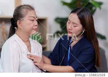Nurse checking elderly woman's heartbeat with stethoscope Nurse checking elderly woman's heartbeat with stethoscope 138812328