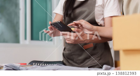 Entrepreneurs using smartphone for online store tasks 138812393