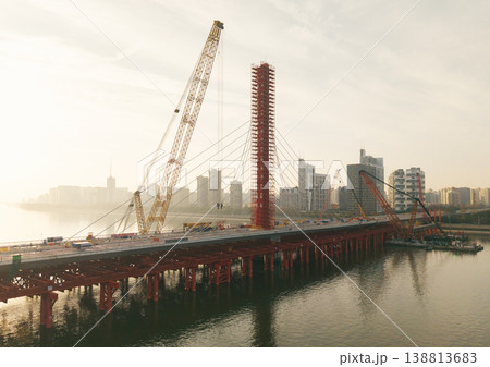 Aerial view of bridge sections being dismantled with a large crane over a river Aerial view of bridge sections being dismantled with a large crane over a river 138813683