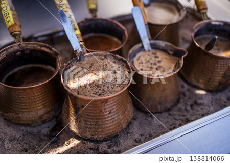 Traditional Turkish Coffee Brewing in Copper Cezve on Sand Traditional Turkish Coffee Brewing in Copper Cezve on Sand 138814066