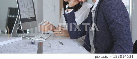 Architects collaborating on architectural project, discussing blueprints and design models on office table. Business and architecture concept 138814531