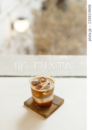 glasses of iced salted caramel milk latte coffee on table by the window. glasses of iced salted caramel milk latte coffee on table by the window. 138814606