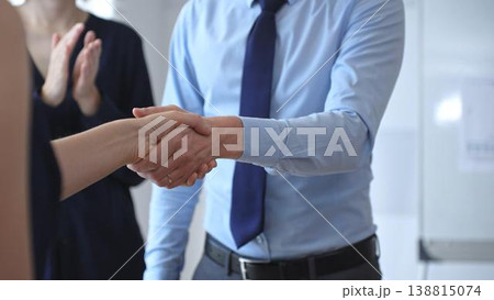 Professional business people shaking hands, concluding a successful partnership agreement and closing a significant deal in an office meeting Professional business people shaking hands, concluding a successful partnership agreement and closing a significant deal in an office meeting 138815074