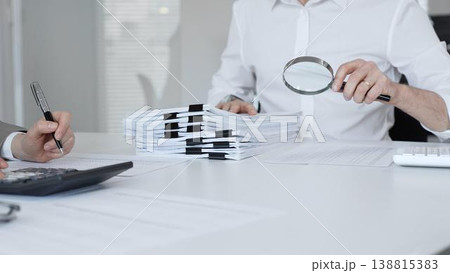 Auditors and financial experts analyzing tax documents, reviewing contract papers, and calculating data for investigation. Audit and taxes in business 138815383
