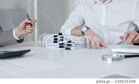 Accountants reviewing financial documents, calculating taxes, and preparing audit reports in a modern office environment. Audit and taxes in business 138815389