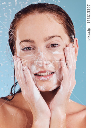 Woman, hands cleaning face and foam with beauty, shower and hygiene with grooming on blue background. Female model in portrait, sustainability and water drops, dermatology and skincare in studio Woman, hands cleaning face and foam with beauty, shower and hygiene with grooming on blue background. Female model in portrait, sustainability and water drops, dermatology and skincare in studio 138815397