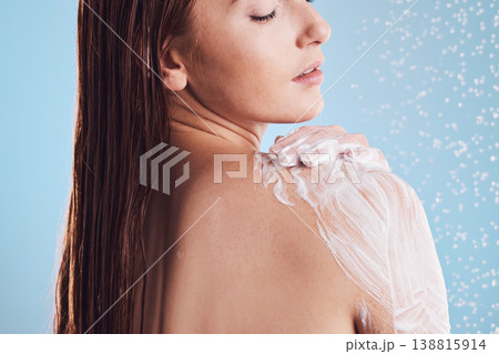 Woman, shower and soap for body hygiene, washing or cleaning against a blue studio background. Female person in relax for soapy scrub, wash or rain drops for skincare, self love or healthy wellness 138815914