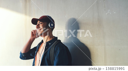 Happy man, student and headphones, listening to music on campus with happiness and audio against wall background. Gen z, education and male person at college, mockup space and podcast streaming Happy man, student and headphones, listening to music on campus with happiness and audio against wall background. Gen z, education and male person at college, mockup space and podcast streaming 138815991
