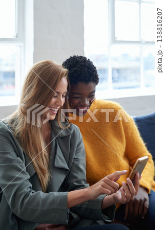 Happy, social media and women with a phone on a work sofa for communication, notification or a chat. Smile, digital and diversity with friends reading from a mobile app, contact or email together 138816207