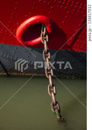 Red boat weighing anchor in deep green water Red boat weighing anchor in deep green water 138817012