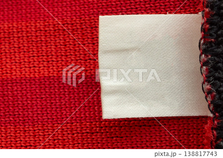 Blank white laundry care clothes label on red shirt fabric texture background Blank white laundry care clothes label on red shirt fabric texture background 138817743
