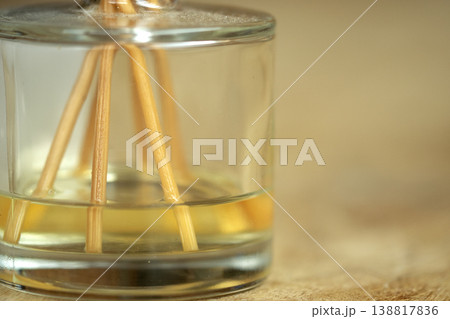 Glass reed diffuser with essential oil on wooden surface for wellness 138817836
