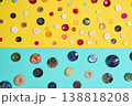 Assorted sewing buttons on yellow and blue background 138818208