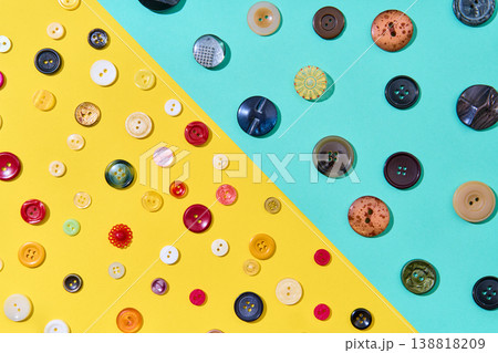 Assorted sewing buttons on yellow and blue background 138818209