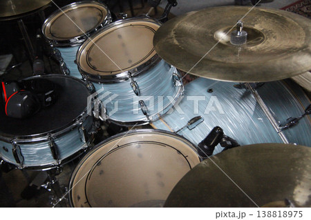 Drums are set up in a music studio with microphones attached. 138818975