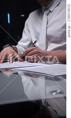 Business man signing a contract late in the office, closing a deal, or completing legal paperwork at deep night. Audit and overworking concepts 138819032