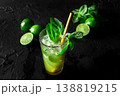 Mojito, summer cocktail with mint and ice, a single glass on black with limes 138819215