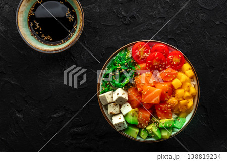 Salmon poke bowl with mango, avocado, tofu, wakame, overhead shot Salmon poke bowl with mango, avocado, tofu, wakame, overhead shot 138819234