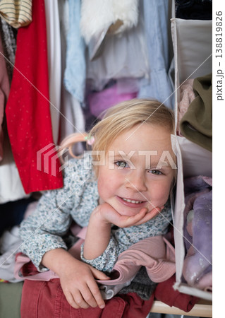 Little 4 Year Old Caucasian Girl Playing Hide-and-Seek Inside a Cluttered Clothes Wardrobe Little 4 Year Old Caucasian Girl Playing Hide-and-Seek Inside a Cluttered Clothes Wardrobe 138819826