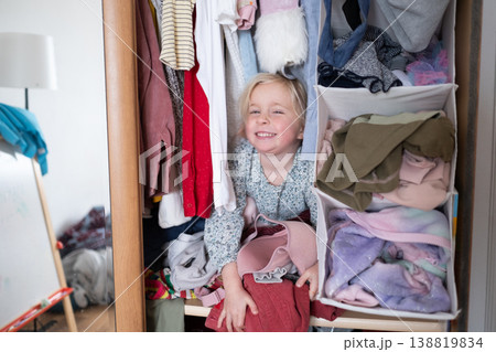 Little 4 Year Old Caucasian Girl Playing Hide-and-Seek Inside a Cluttered Clothes Wardrobe Little 4 Year Old Caucasian Girl Playing Hide-and-Seek Inside a Cluttered Clothes Wardrobe 138819834