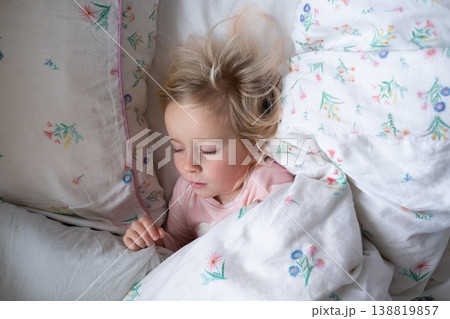 Peaceful 4 year old girl sleeping in cozy pajamas in a sunlit bedroom Peaceful 4 year old girl sleeping in cozy pajamas in a sunlit bedroom 138819857