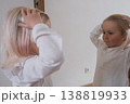 Funny little girl making faces in front of the mirror. 138819933
