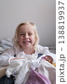 Laughing little girl sitting on the bed in a cozy bedroom. 138819937